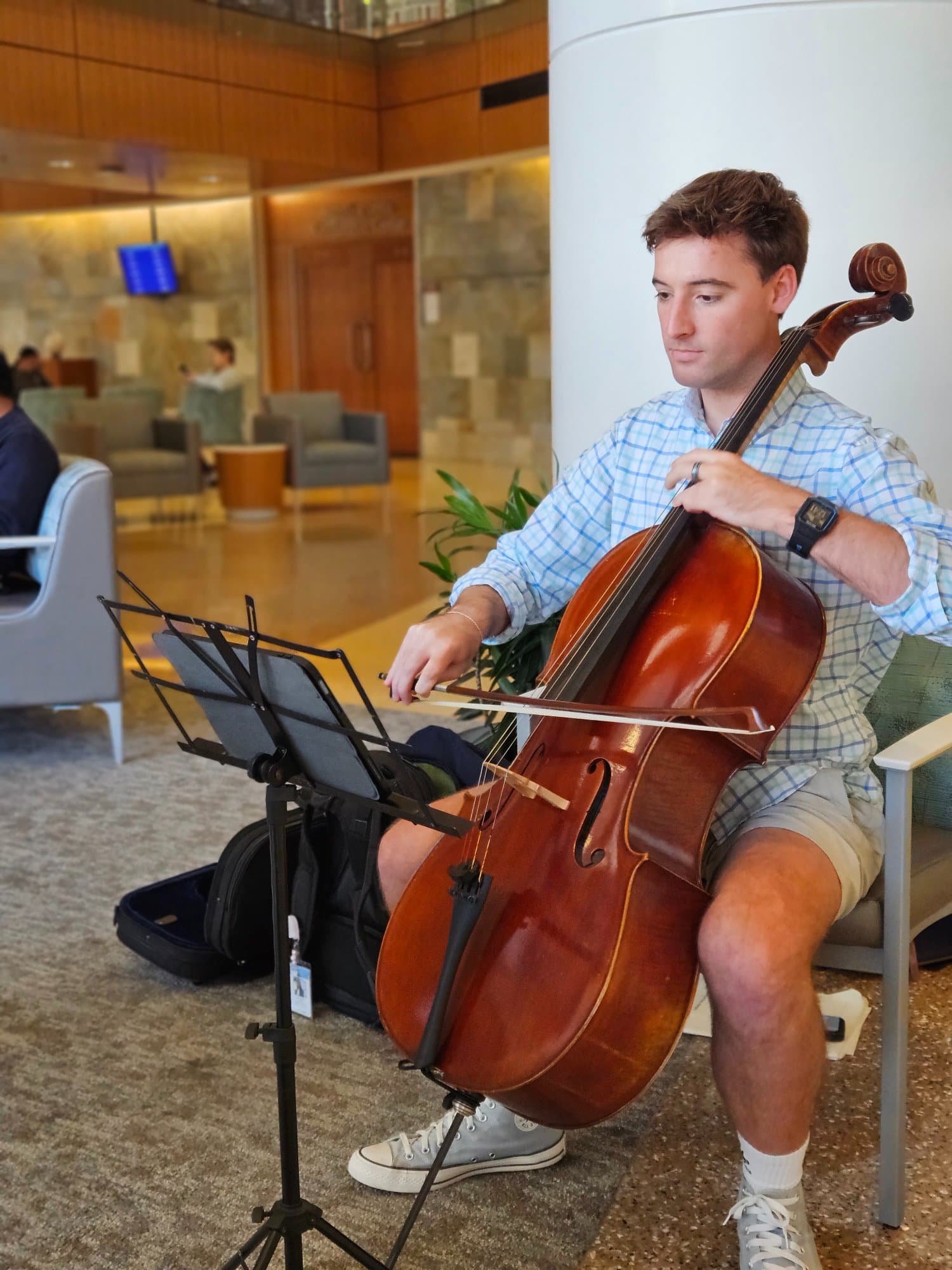 A cellist performing in a UNC Health hospital lobby